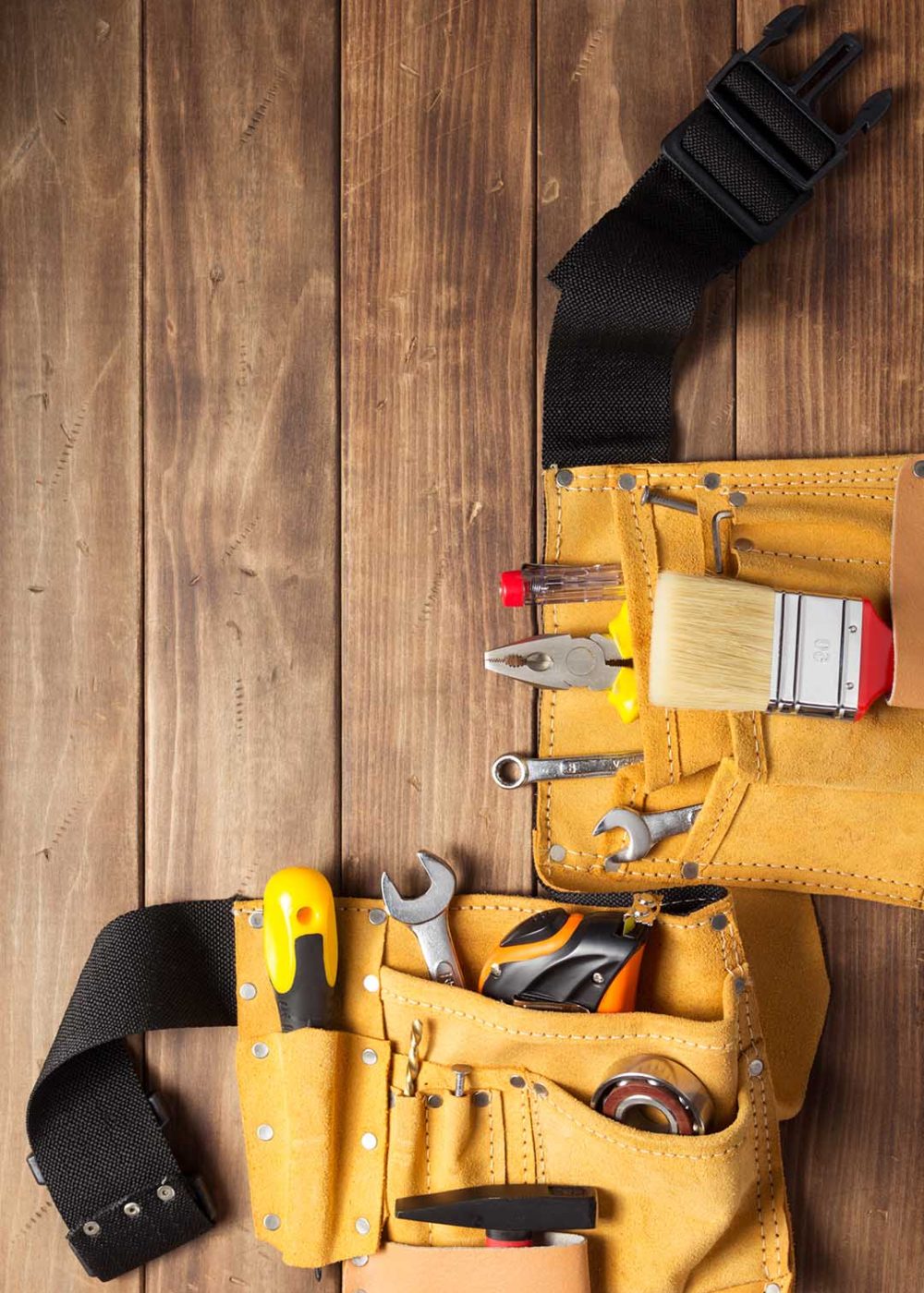 instruments in tool belt at wooden table surface background