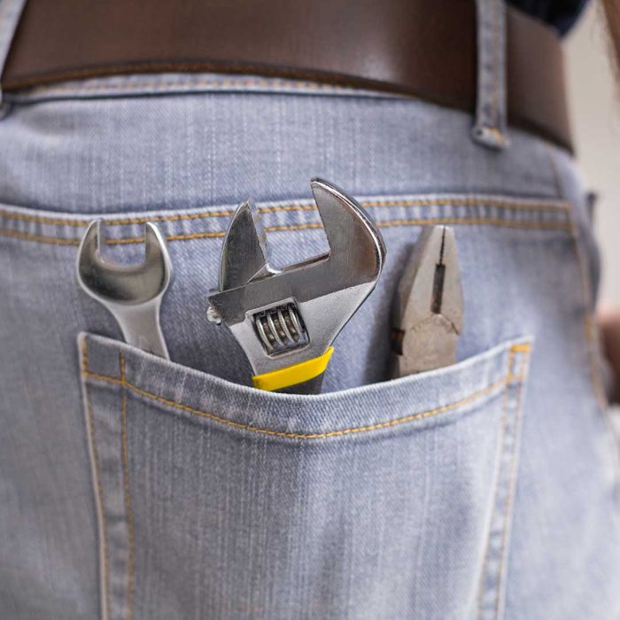 Handyman with tools in back pocket in the kitchen