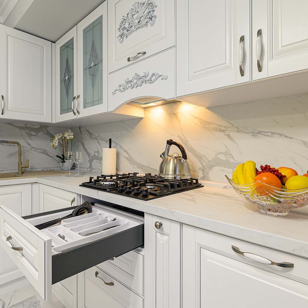 Open drawer with cutlery at modern white woden kitchen in classic style